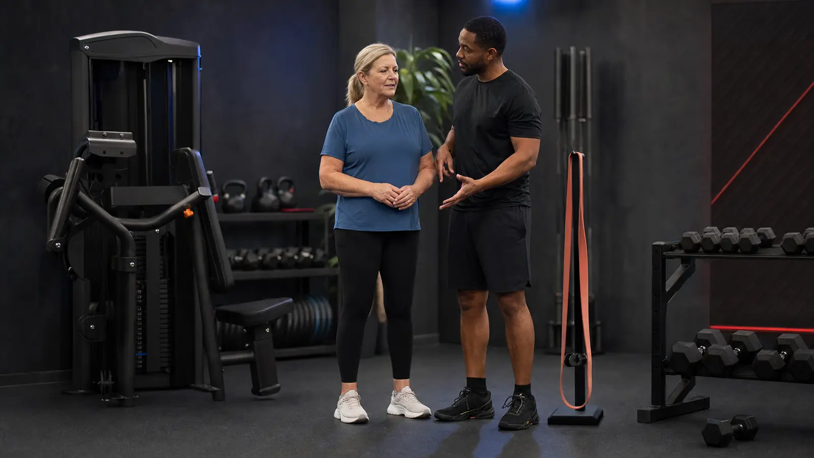 AI-generated editorial image of an anonymous beginner and coach comparing a machine, band, and dumbbell