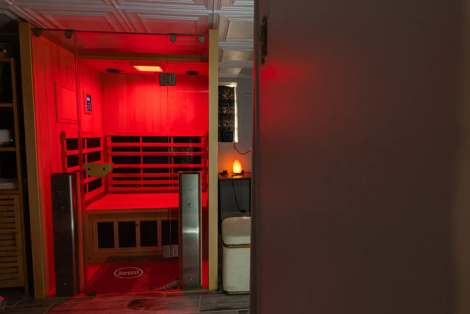 Red-lit infrared sauna cabin in the Heaven recovery space