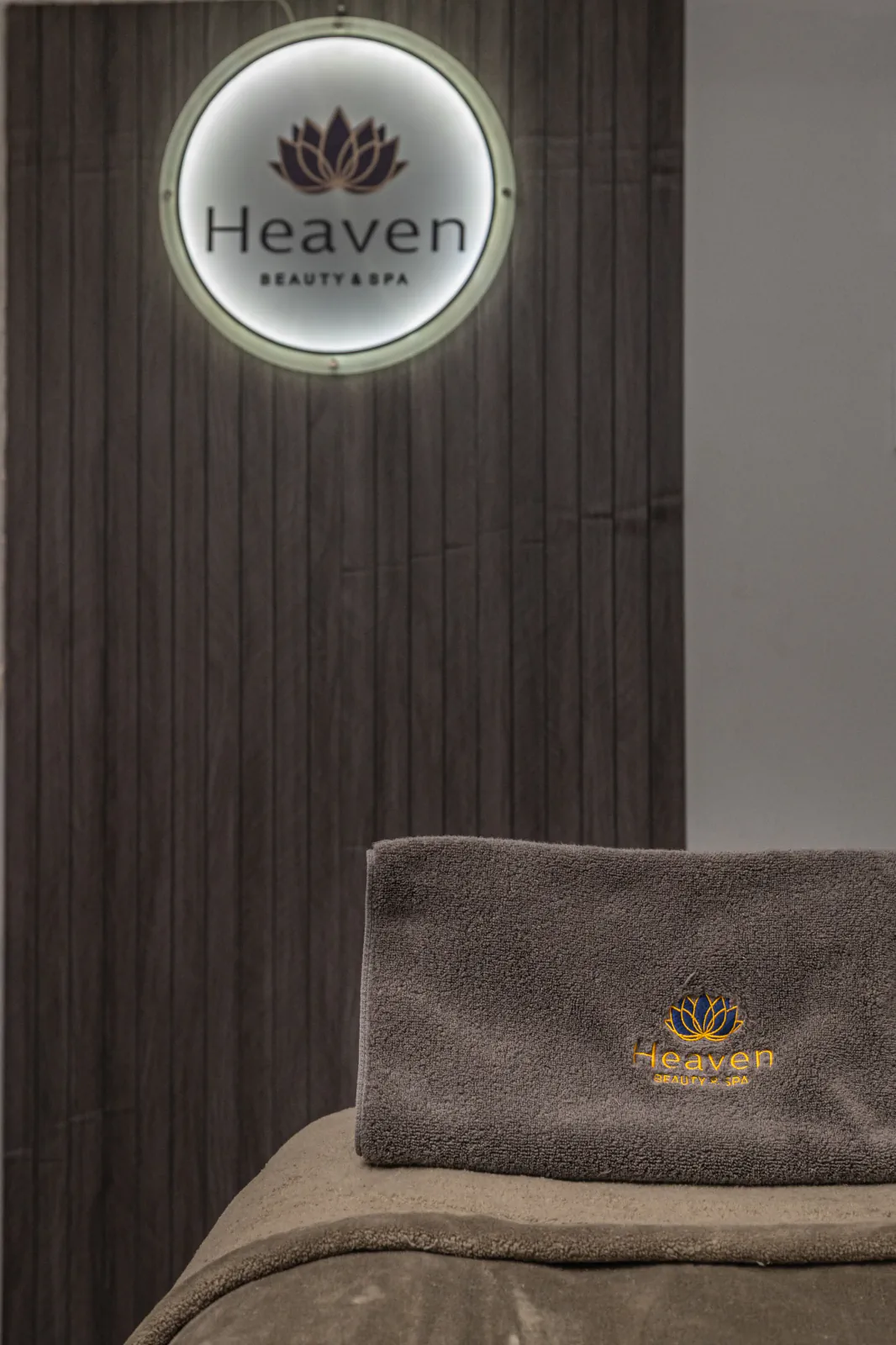 Heaven Beauty and Spa relaxation chair beneath the illuminated logo