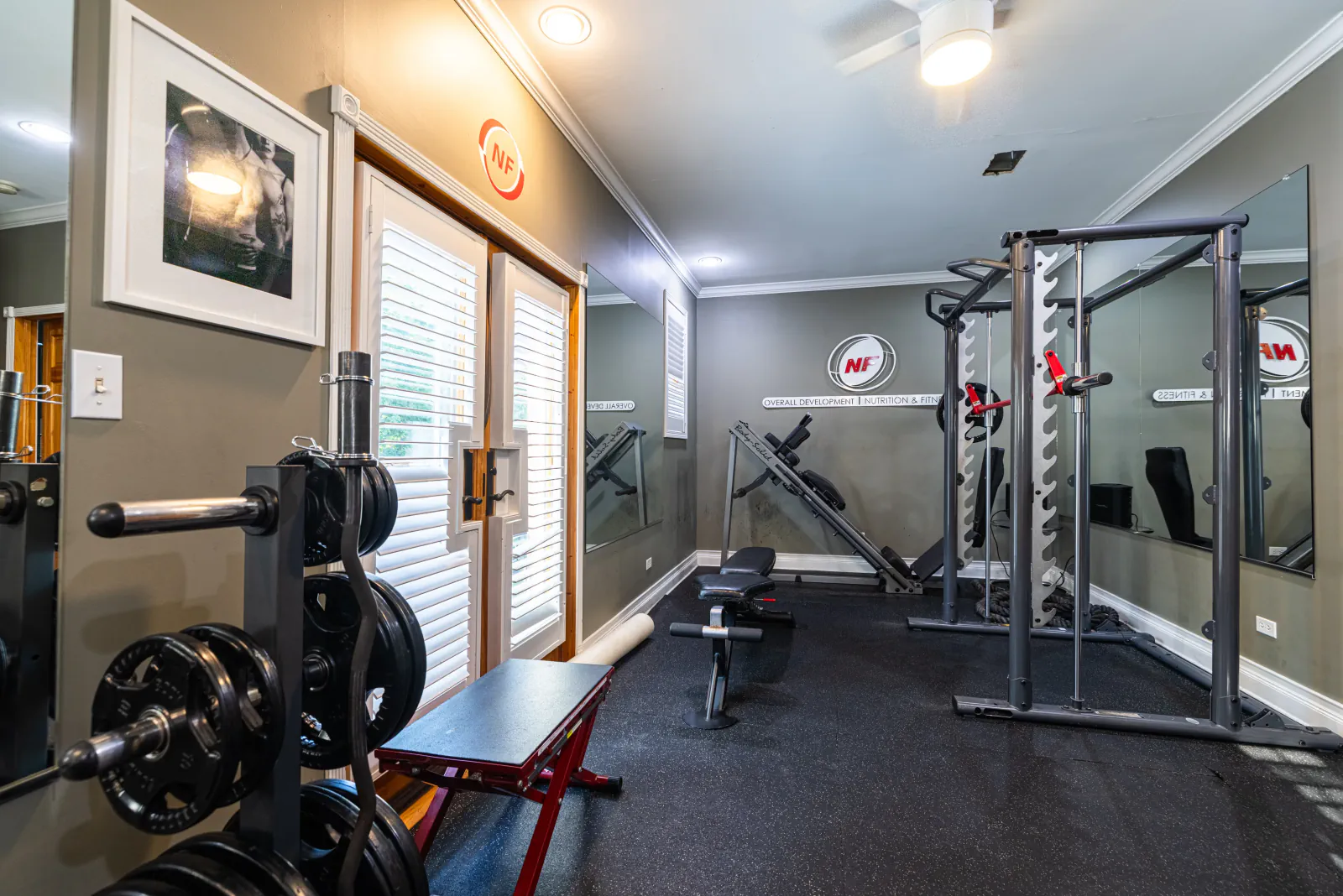 Overall Development strength room with rack, bench and plate storage